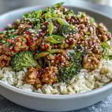 Sweet and Spicy Turkey Broccoli Bowls topped with green onions, sesame seeds, and steamed broccoli florets.