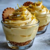 Bright lemon mousse cups with buttery shortbread cookies, garnished with fresh berries and mint leaves.