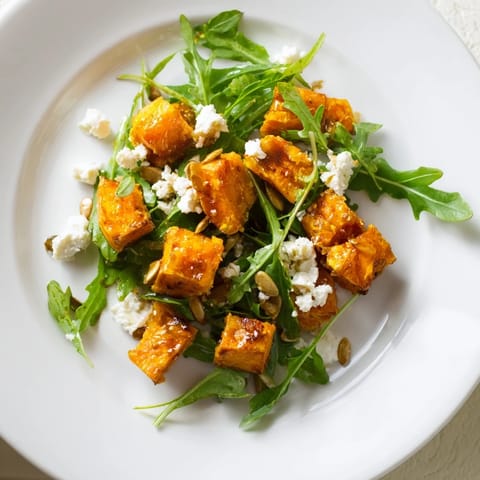 Roasted sweet potato salad topped with crumbled feta, red onion, and toasted pepitas on a bed of fresh arugula.