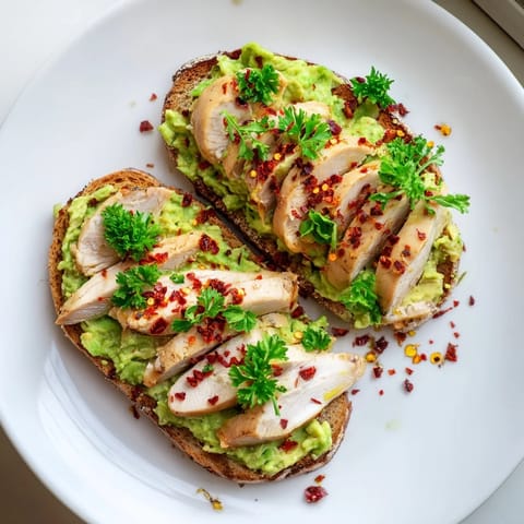 Hearty Smashed Avocado Chicken Toast features juicy sliced chicken, smooth avocado mash, and a spicy-sweet honey finish, perfect for a quick brunch or lunch.  
