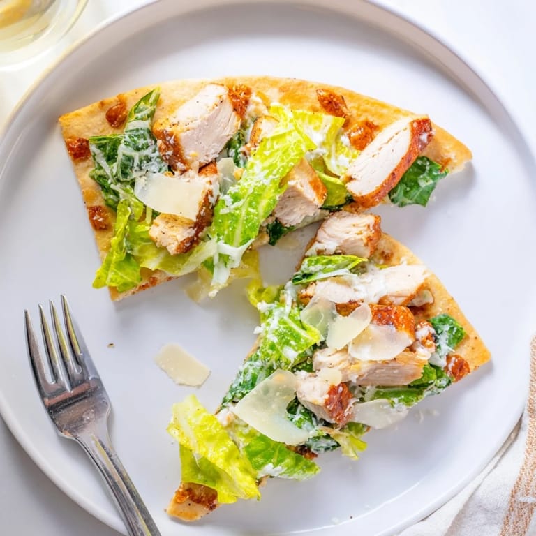 Freshly made Chicken Caesar Flatbread featuring a crunchy crust, tender chicken, and vibrant romaine with cherry tomatoes.