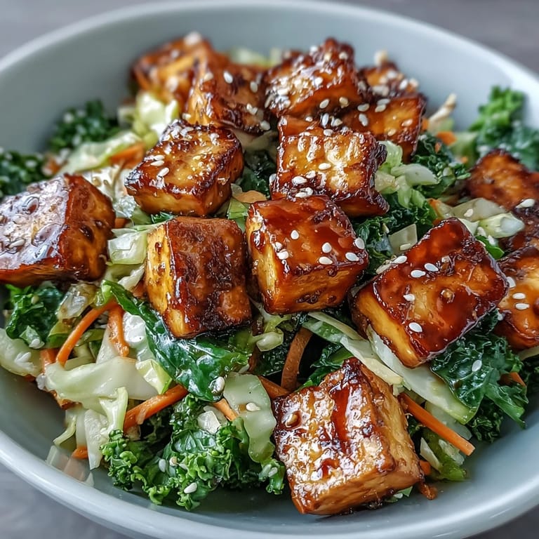 High-protein vegan egg roll in a bowl featuring golden tofu, crisp greens, and a savory sauce, garnished with sesame seeds.