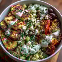 Golden-charred zucchini and bell peppers on a bed of fluffy quinoa topped with grilled chicken and creamy tzatziki in the Healthy Grilled Mediterranean Bowl.