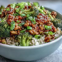 A close-up of Sweet and Spicy Turkey Broccoli Bowls showing glazed turkey and fluffy brown rice.